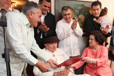 el presidente de la Asamblea Nacional, Fernando Soto Rojas, entrega la distinción al Tío Simón. 