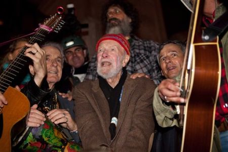 El veterano músico y activista Pete Seeger, de 92 años, al centro, canta ante una muchedumbre de casi 1.000 manifestantes que respaldan el movimiento Ocupemos Wall Street en el Columbus Circle, en Nueva York, el sábado, 22 de octubre del 2011. © John Minchillo/AP