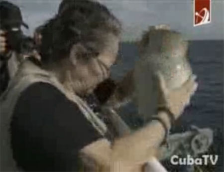 La compañera de Sara González, Diana Balboa, arroja las cenizas de la trovadora cubana a la Bahía de la Habana. © Cuba TV