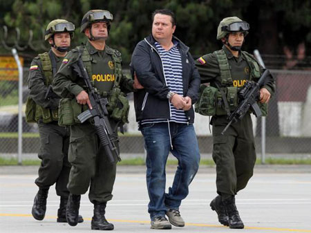 Alejandro Jiménez, alias «El Palidejo» es ecoltado por tres policías colombianos. © EFE