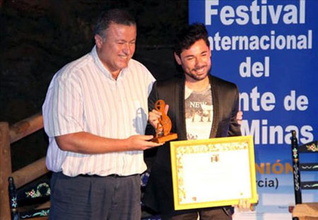 El cantaor Miguel Poveda recibiendo el Trofeo Pencho Cros de manos del alcalde de La Unión y presidente del Comité Ejecutivo de la Fundación Cante de las Minas, Francisco Bernabé. © Festival Cante de las Minas