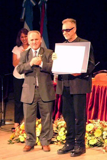 León Gieco recibe de manos del rector de la Universidad Nacional de Entre Ríos, Jorge Gerard, el título de Doctor Honoris Causa. 