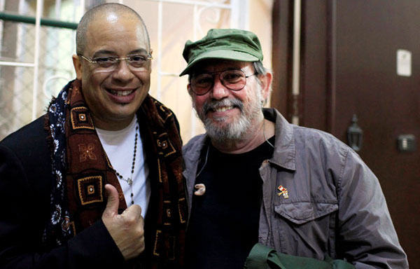 El cantautor cubano Silvio Rodríguez, a la derecha, posa con su compatriota y músico Issac Delgado, que vive en Estados Unidos, luego de que el veterano lo invitara cantar en el escenario de un barrio popular de La Habana, el viernes 29 de marzo de 2013. © Franklin Reyes