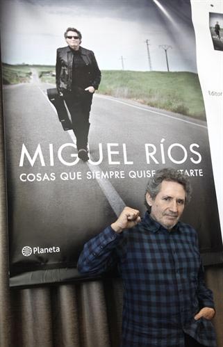 Miguel Ríos posando ante la portada de su libro. © EP