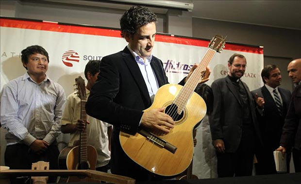 El tenor peruano Juan Diego Flórez (c) fue registrado este lunes al tocar una guitarra, junto a unos niños pertenecientes a su proyecto social Sinfonía por el Perú, en Lima (Perú). © EFE