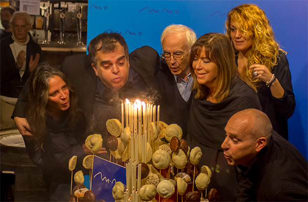 Maria del Mar Bonet sopla las cincuenta velas de su torta formada por ensaimadas —un alimento típicamente mallorquín— acompañada por (de izquierda a derecha): Teresa Roig, autora de su recién estrenada WEB; Yanni Munujos, manager de Maria del Mar; Josep Maria Espinàs, escritor, periodista y primer miembro de «Els Setze Jutges»; Laura Magrinyà, del equipo de management; y Oriol Ferrer, comisario del «Año Bonet». © Xavier Pintanel