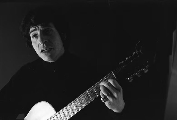 Víctor Jara cantando y tocando guitarra en la casa de Hernán Quintana (1967). © Hernán Quintana|Archivo de la Escena Teatral UC
