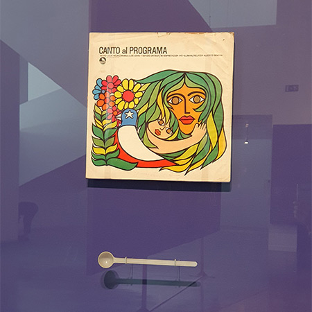 Portada del disco «Canto al programa» de Inti-Illimani y una cuchara dosificadora de leche en polvo. © Xavier Pintanel