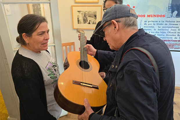 Amanda Jara junto a Silvio Rodríguez, quien sostiene la guitarra de Víctor Jara. © Constanza Yáñez|Fundación Víctor Jara