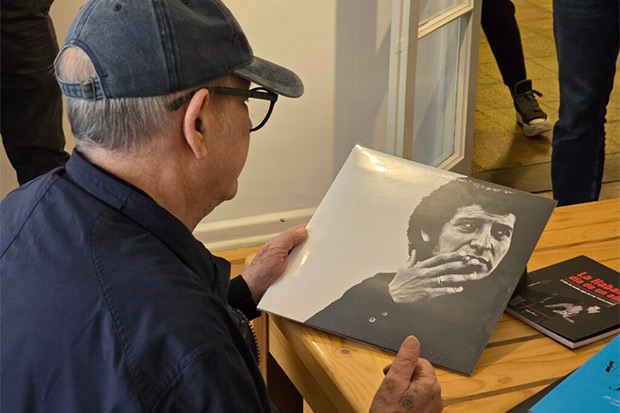 Silvio Rodríguez sostiene un ejemplar de «El derecho de vivir en paz» de Víctor Jara. © Constanza Yáñez|Fundación Víctor Jara